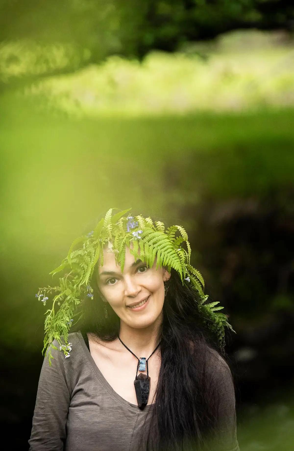 Portrait of a smiling dark-hair girl wearing a wreath made of leaves